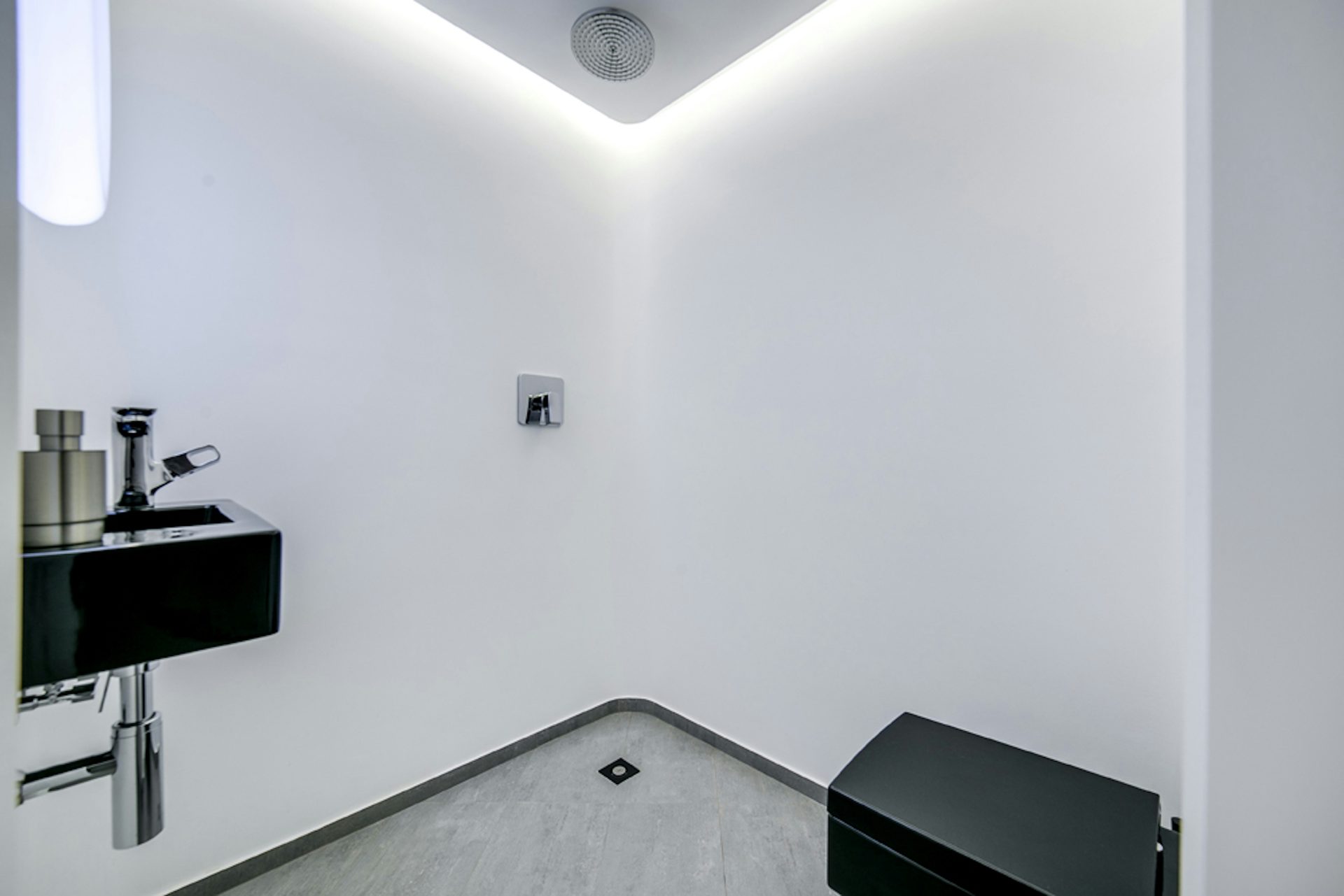 Un baño blanco con lavabo y espejo negros